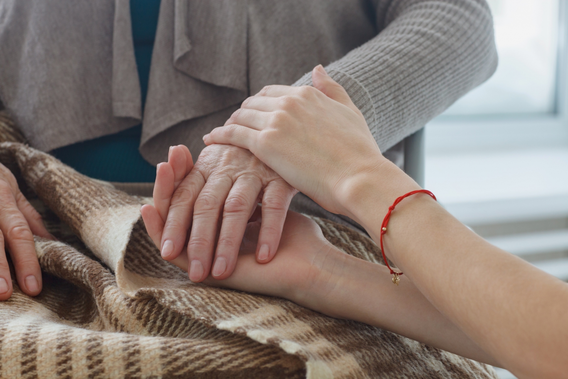 老人とスタッフの手